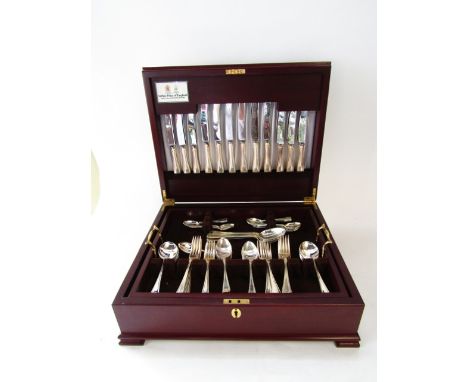 A good quality timber cutlery canteen with hinged lid and removable shelf with brass handles to interior containing a quantit