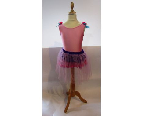 A child's contemporary ballet outfit in shades of purple and pink with net overlay skirt, the shoulders decorated with flower