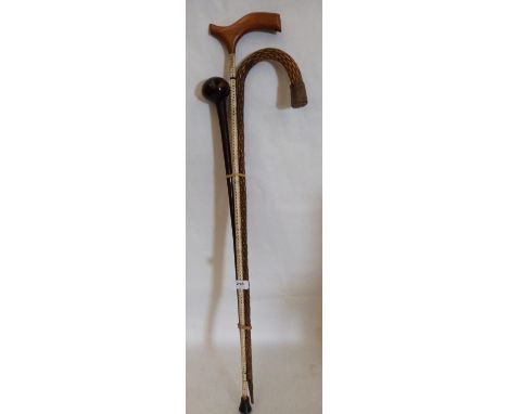 A shark vertebrae walking stick, a French plaited straw example and a hardwood knobkerrie stick