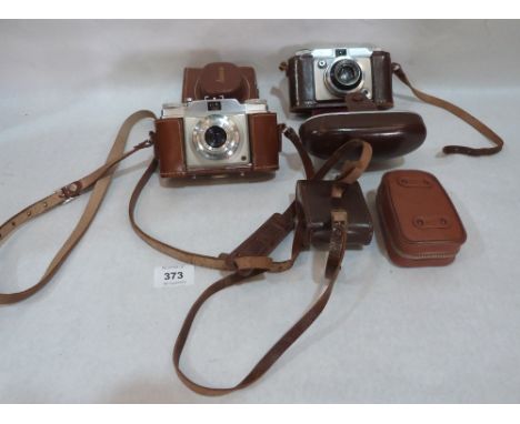 A Dacora Dignette 35mm camera; An Ansco Memar Pronto 35mm camera; a flash gun and a light meter. c.1955