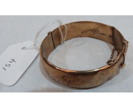 A foliate engraved hinged bangle. In gold marked 375. 21.7g