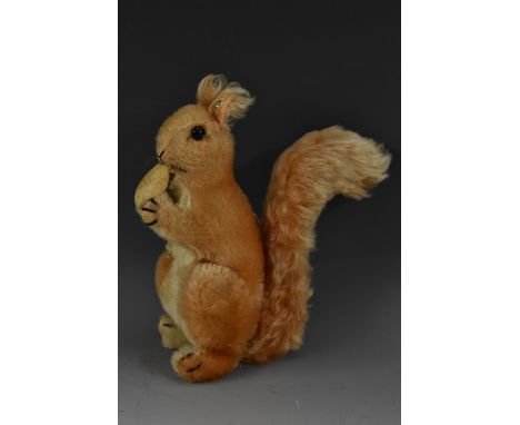 Steiff Toys - a mid 20th century stuffed toy, Squirrel Eating a Nut, button to ear, 21cm high, c.1955