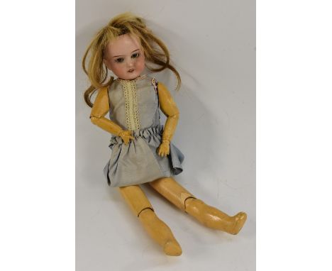 Schoenau & Hoffmeister  - a porcelain head doll, fixed brown eyes, open mouth with teeth, light brown wig, impressed marks, 1