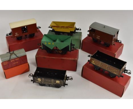 A Hornby Gauge 0 Goods Brake Van, LMS; another NE; a Wagon with Sheet Rail, LMS; a No.50 Rotary Tipping Wagon, Trinidad Lake 