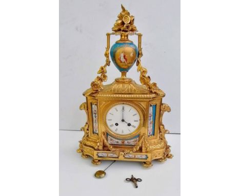 A 19th century French gilt mantle clock surmounted by a Sevres-style urn with classical depiction and floral decoration, Roma