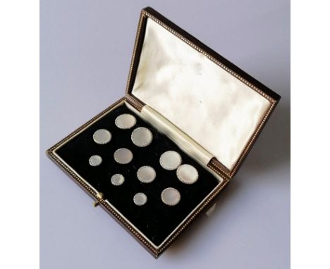 A cased mother of pearl and gold dress set comprising: a pair of double sided cufflinks, four shirt studs and three collar st