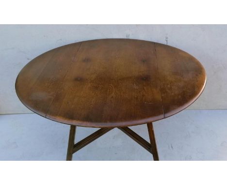 An Ercol beech and elm drop leaf table with X-shape stretcher, blue label, 72 cm H, 113 cm diameter, in good structural condi