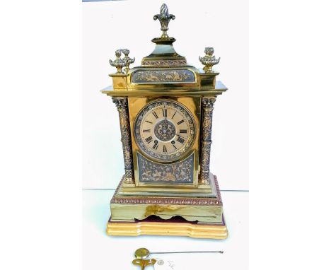 A French 19th century brass mantle clock with Roman numerals, carved bezel with mechanism by AD Mougin, 50 cm H without base
