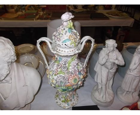 A large floral encrusted ceramic vase & cover