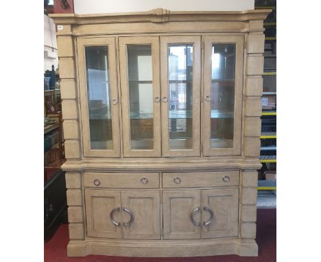 A substantial continental dresser in crème factory finish. Having four door glazed top section over two long drawers featurin