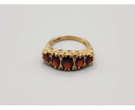 Ladies 9ct yellow gold 5 stone garnet ring comprising of 5 oval shaped garnet stones with 8 smaller cubic zirconia size o1/2 