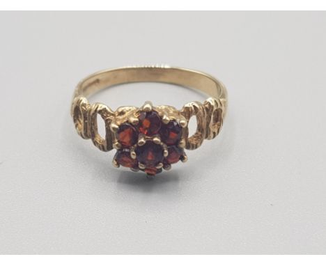 Ladies 9ct yellow gold garnet cluster ring comprising of 7 brilliant round cut garnet stones all the stones are claw set size