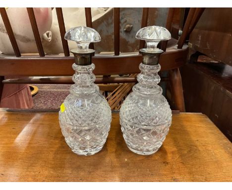 Pair of cut glass decanters and stoppers with silver collars, 29cm high