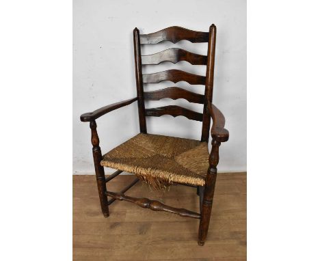 Early 19th century ash and elm ladder back armchair, with caned seat