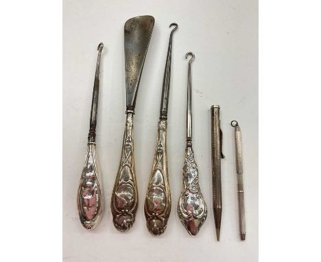 Three silver handled button hooks, silver handled shoe horn, one silver pencil and one other silver plated pencil (6)