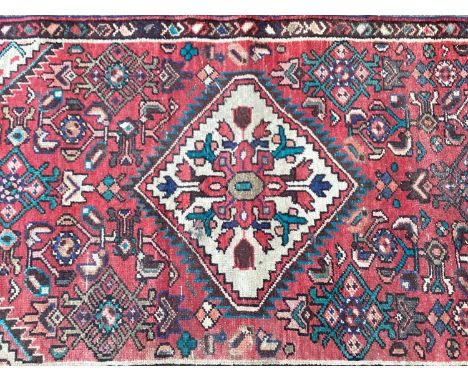 Hamadan runner with three medallions and geometric ornament on brick-red ground, 342cm x 76cm