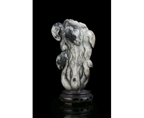 A MOTTLED JADE CARVING OF A CHINESE CABBAGE CHINA, QING DYNASTY Naturalistically carved in a mottled stone with dark inclusio