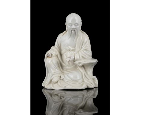 A DEHUA / BLANC DE CHINE MOLDED PORCELAIN FIGURE OF A SAGE, POSSIBLY LAOZI 老子 CHINA, QING DYNASTY He is represented seated in