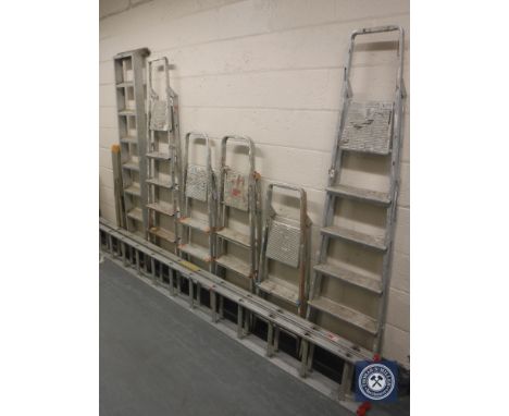 Seven aluminium step ladders and an extension ladder