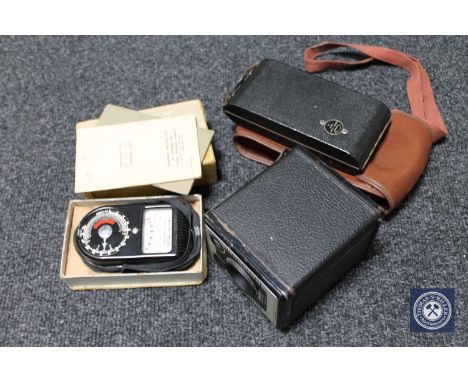 A box containing boxed Brownie camera, light meter, together with a cased mid 20th century camera