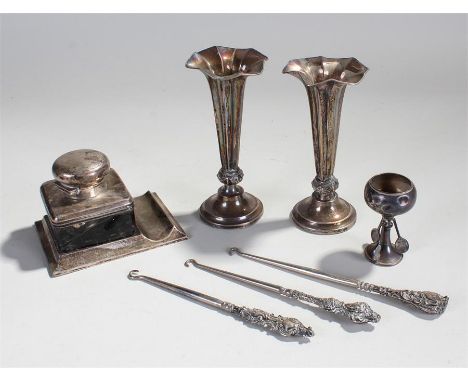 Mixed silver, t include a desk inkwell with pen ledge, two silver vases, a silver trophy and silver handled button hooks, (7)