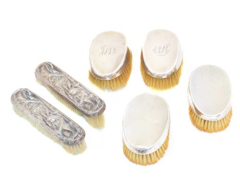 Six silver backed brushes, two with embossed figural decoration, Williams Ltd, Birmingham, 1904, two oval shaped brushes with