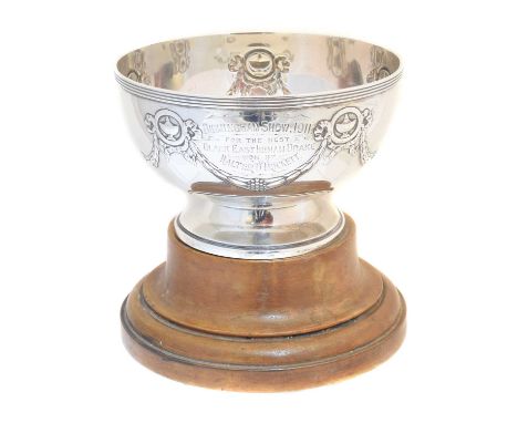 A George V silver presentation cup, with embossed swag detailing, inscription dated 1911 and accompanying wooden stand, hallm