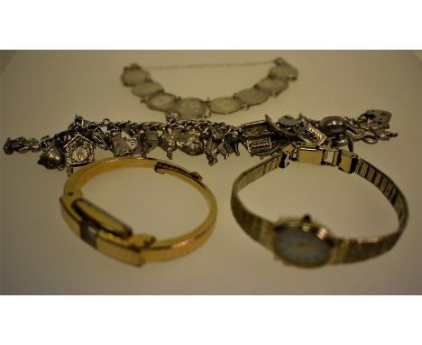 A white metal coin bracelet, and a white metal curb bracelet with approx thirty charms attached including windmill, poodle, c