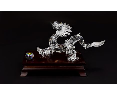 Swarovski Crystal Zodiacs Figure 'Fables and Tales' Dragon and Crystal Ball with wooden stand, polished teak. Designer Gabrie