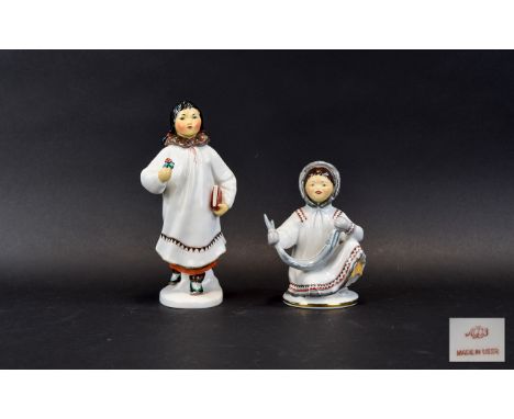 Two Lomonosov Russian Ceramic Figures Each in the form of a young Siberian girl. The first depicts a kneeling girl holding a 