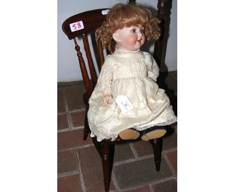 An antique bisque head doll - marked K & H to the back - with original clothing and rolling eyes - 36cm, together with a doll