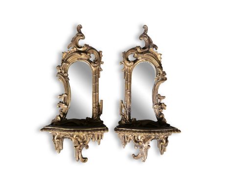 A PAIR OF SMALL 19TH CENTURY CARVED GILTWOOD MIRRORS IN THE ROCOCO TASTE, of shaped rectangular form, fitted with shelf and b