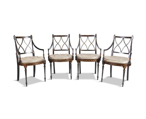 A SET OF FOUR REGENCY EBONISED AND PARCEL GILT OPEN ARMCHAIRS, with rail backs and interlocking X shaped splats, above caned 