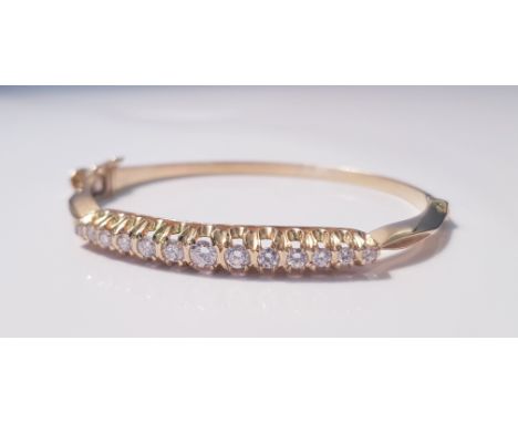 A yellow metal and diamond bangle, 13 diamonds to bangle, approx. weight 21gms. On line viewing and bidding only. No in perso