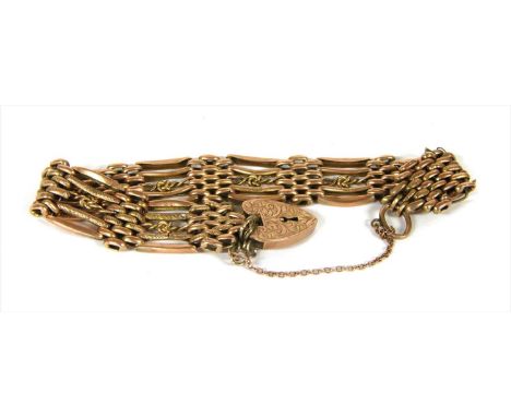 A gold five row gate bracelet, a central knotted wire row with a straight textured bar and outer plain bowed bar at each side