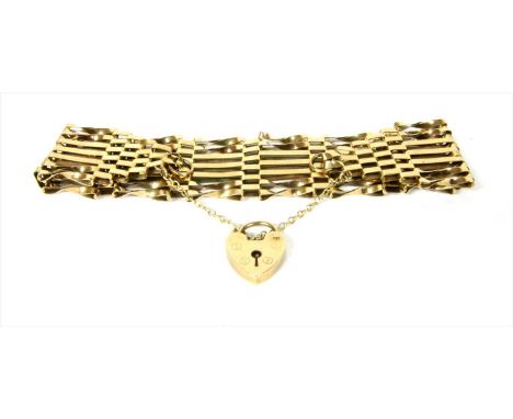 A 9ct gold seven row gate bracelet, central plain bars to outer pairs of twisted bars, with safety chain and heart shaped pad