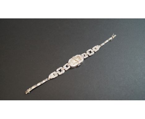 An Art Deco platinum cocktail watch, encrusted with brilliant cut and baguette diamonds. Condition Report: In good order over