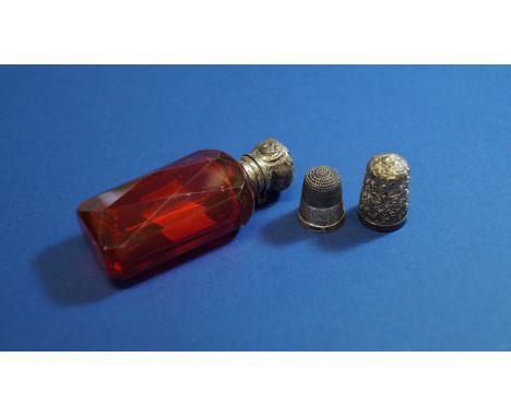 A Victorian cut ruby glass scent bottle, having plated lid, and two silver thimbles.