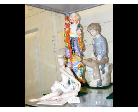 Oriental deity figure, together with a Nao style figure of seated boy and Lladro ballerina 