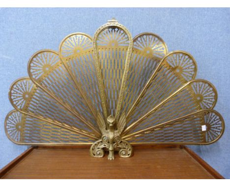 A vintage brass peacock fire screen 