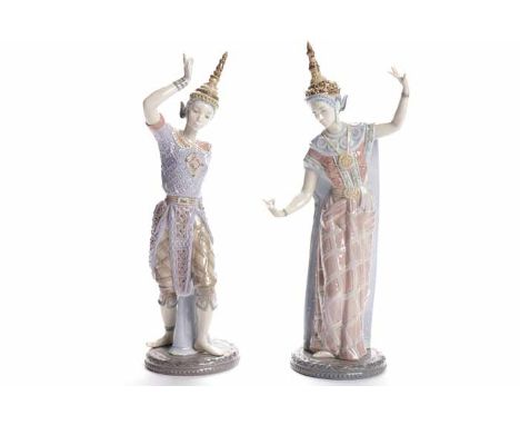 PAIR OF LLADRO FIGURES OF BURMESE DANCERS each posed with arms aloft and outstretched, each over a circular base, blue printe