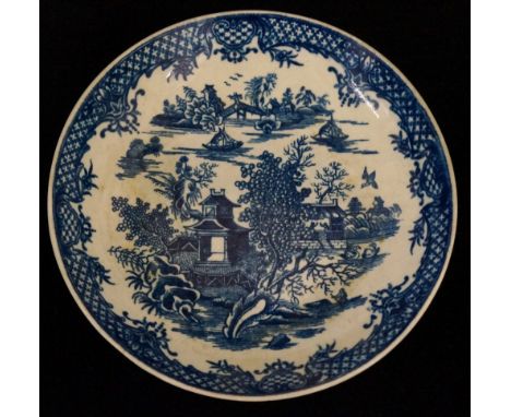 A Worcester circular dish printed in under glaze blue with fishing boats, temples and trees within a formal hatched border, 1