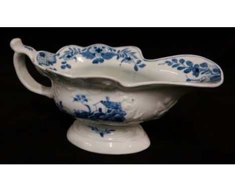 A Worcester sauce boat painted in under glaze blue with fishermen, buildings and trees in relief moulded panels, the interior