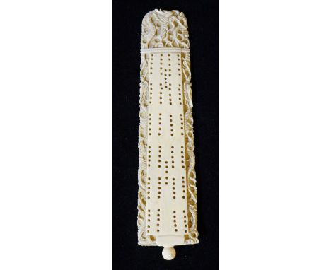 A Chinese cribbage board or games marker of tapered rectangular form the peg holes surrounded by relief carved stylised drago