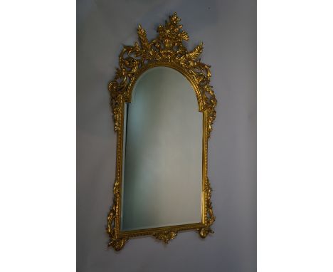 A reproduction giltwood mirror in George I style the elaborate frame scroll carved with flower filled urn, bevelled plate, 14