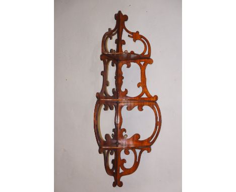 A Victorian mahogany corner wall shelf, the three serpentine-shaped shelves supported on scrolling fret-pierced sides, 82 cm 