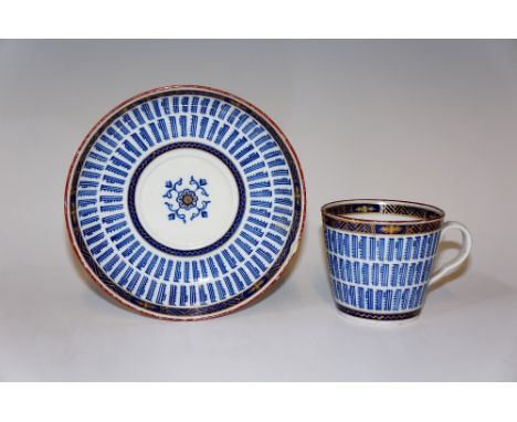 A Worcester porcelain music pattern cup and saucer with hatched Royal blue and gilt borders, red line rim, saucer 13.5 cm dia