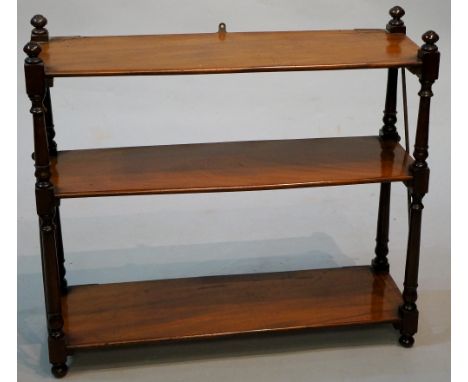 A George IV mahogany hanging wall shelf the three figured shelves supported on turned pillars, 62 cm high, 69 cm wide, Circa 