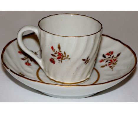 A Worcester spirally fluted miniature cup and saucer decorated with orange and gilt sprigs, the saucer centre with conforming
