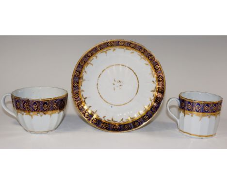 A Worcester lobed trio, with band of gilt filled ovals on a Royal blue ground, saucer 14.5 cm diameter, Circa 1800
